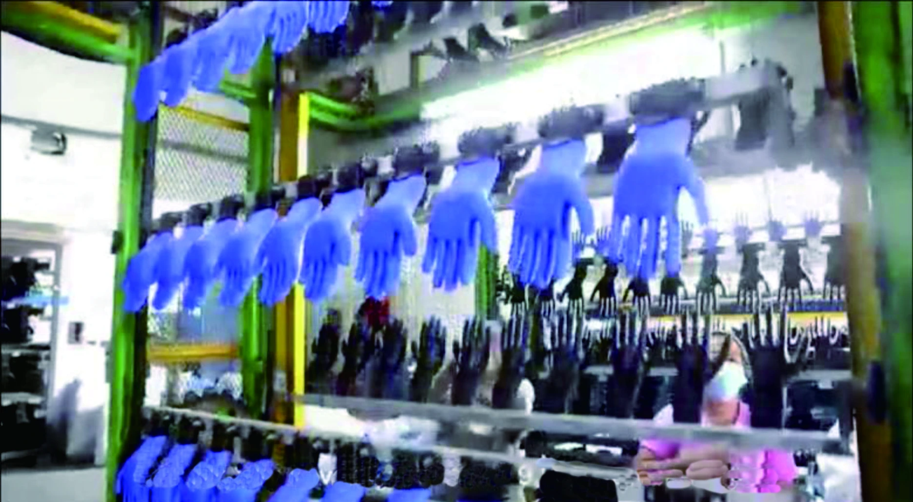 Work gloves moving through a factory dipping line